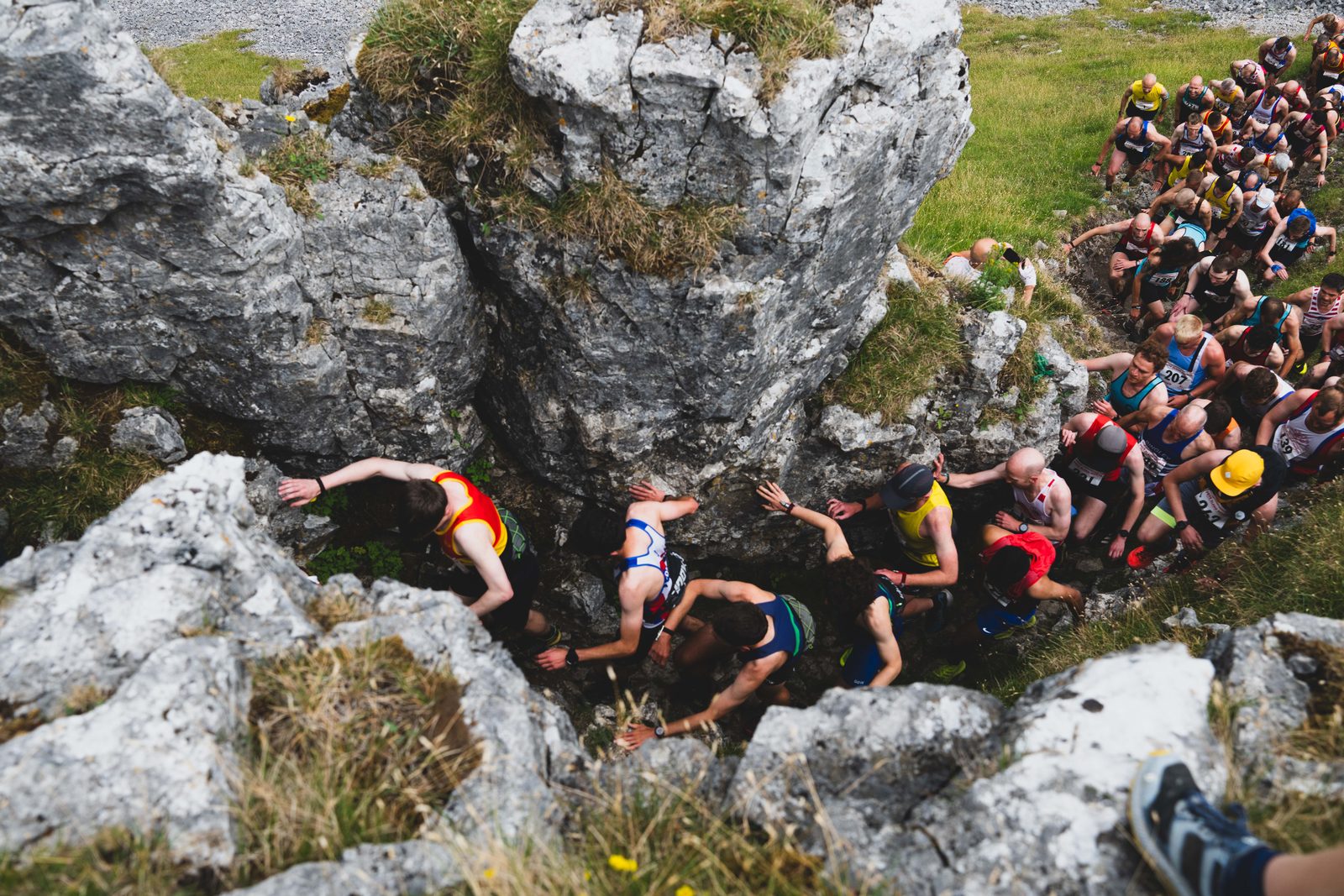 A long line of fell runners scrambling up through the limestone rocks of Kilnsey Crag