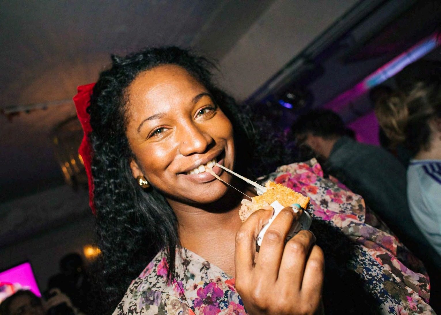Guest smiling while eating the Idiot Sandwich at the launch party